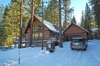 a car parked in front of a house in the snow at 1116 Golden Bear home in South Lake Tahoe