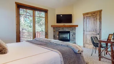 a bedroom with a bed with a fireplace and a television at Graystone #2024 home in Mammoth Lakes