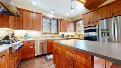 a large kitchen with wooden cabinets and stainless steel appliances at Graystone #2024 home in Mammoth Lakes