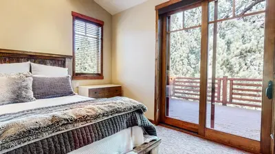 a bedroom with a bed and a sliding glass door at Graystone #2024 home in Mammoth Lakes