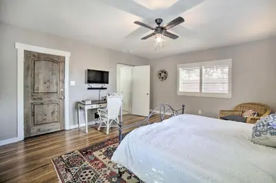 a bedroom with a bed with a ceiling fan and a desk at Hot Tub and Walk to Midtown! Reno Retreat in Reno
