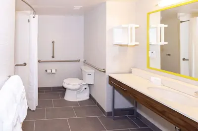 a bathroom with a toilet and a sink and a mirror at Hampton Inn Selma, Ca in Selma