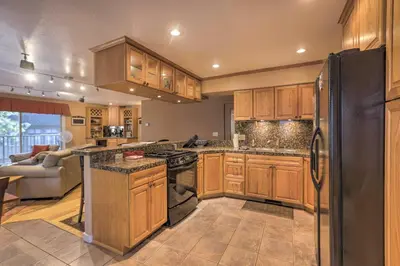 a kitchen with wooden cabinets and a black refrigerator at 3 Mi to Skiing! Incline Village Retreat with Sauna in Incline Village