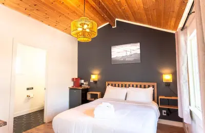 a bedroom with a white bed with a wooden ceiling at Tahoe Mountain Inn in South Lake Tahoe