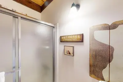 a bathroom with a shower and a sign on the wall at Kings Beach Cozy in Kings Beach