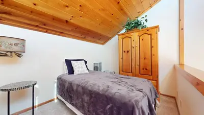 a bedroom with a bed and a wooden ceiling at Mammoth Sierra Townhomes #18 condo in Mammoth Lakes