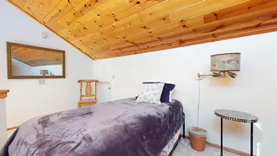 a bedroom with a bed and a wooden ceiling at Mammoth Sierra Townhomes #18 condo in Mammoth Lakes