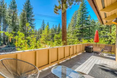 a balcony with chairs and a grill and trees at Incline Village Charmer in Incline Village