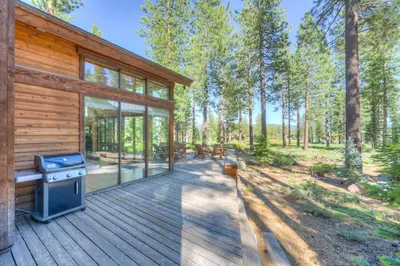a log cabin with a grill on a wooden deck at Sierra Vista in Truckee