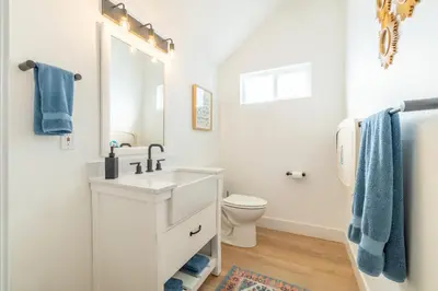 a white bathroom with a sink and a toilet at Luxury 4-bed home in Riverside Heights! in Reno