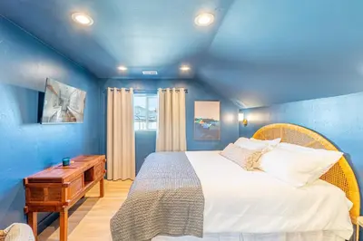 a blue bedroom with a bed and a wooden table at Luxury 4-bed home in Riverside Heights! in Reno