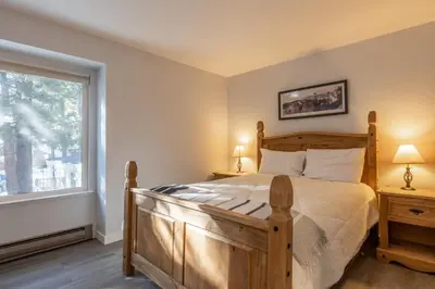 a bedroom with a wooden bed and a window at Horizons IV 180 New Luxurious Listing Fully Remodeled 2 Bedrm Plus Loft 2 and a half Bathrm Sleeps 8 in Mammoth Lakes