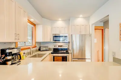 a kitchen with white cabinets and a stainless steel refrigerator at Granlibakken Getaway - #72A in Tahoe City