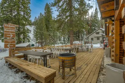 a wooden deck with tables and chairs in the snow at Granlibakken Getaway - #72A in Tahoe City