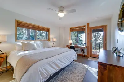 a bedroom with a bed and a desk and windows at 4 Mi to Slopes! Hot Tub Haven with Lake Tahoe Views in Incline Village