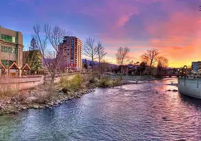 a river in a city with a sunset in the background at Panorama Place in Reno