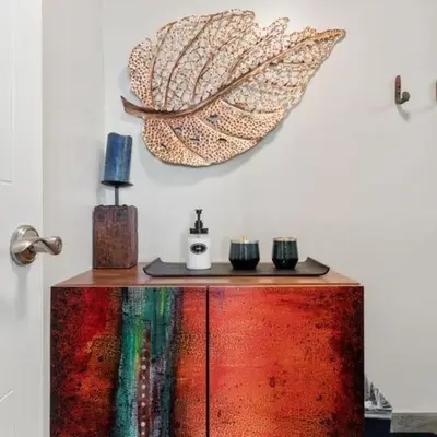 a wooden cabinet with a large leaf on the wall at Panorama Place in Reno