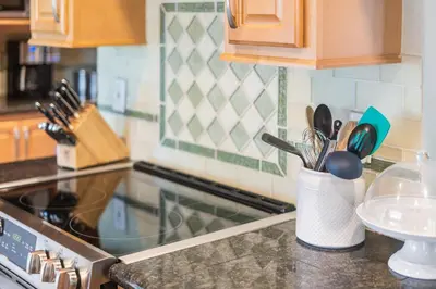a kitchen counter with a stove and a cup of utensils at Reno Roost in Reno