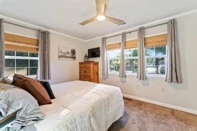 a bedroom with a bed with windows and a ceiling fan at Reno Roost in Reno