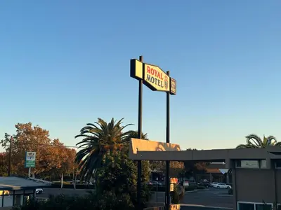 a sign for a restaurant on top of a gas station at ROYAL MOTEL TRACY in Tracy