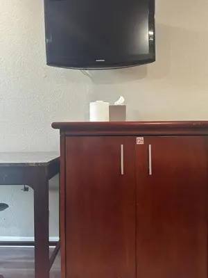 a flat screen tv on top of a wooden cabinet at ROYAL MOTEL TRACY in Tracy