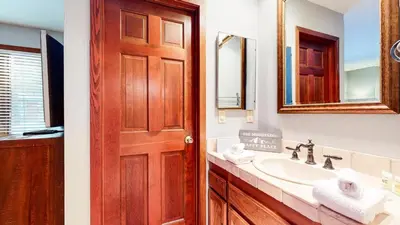 a bathroom with a sink and a wooden door at Woodlands #11 condo in Mammoth Lakes