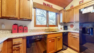 a kitchen with wooden cabinets and a sink and a window at Winterset #3 condo in Mammoth Lakes