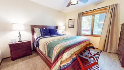 a bedroom with a bed and a dresser and a window at Winterset #3 condo in Mammoth Lakes