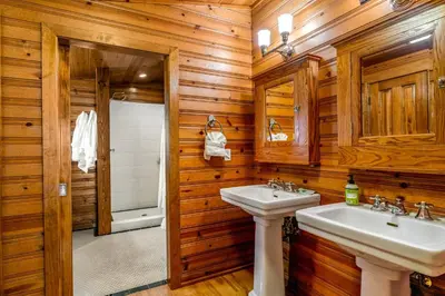 a bathroom with two sinks and wooden walls at Cabin in Soda Springs in Soda Springs