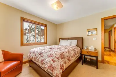 a bedroom with a bed and a chair and a window at Cabin in Soda Springs in Soda Springs