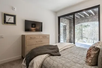 a bedroom with a bed with a dresser and a window at Creekhouse 1553 in Mammoth Lakes