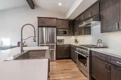 a kitchen with stainless steel appliances and wooden cabinets at Creekhouse 1553 in Mammoth Lakes