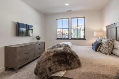 a bedroom with a bed with a dresser and a tv at Creekhouse 1553 in Mammoth Lakes