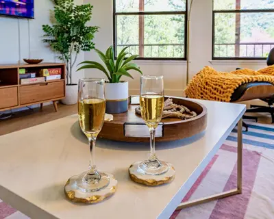 two glasses of champagne on a table in a living room at Secluded Mtn Top Family Haven w/Views Spa & Arcade in Three Rivers