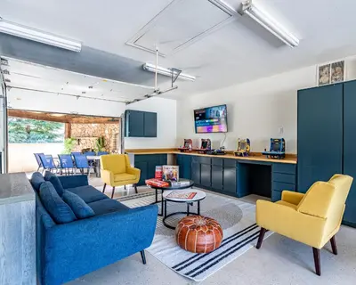 a living room with blue cabinets and yellow chairs at Secluded Mtn Top Family Haven w/Views Spa & Arcade in Three Rivers