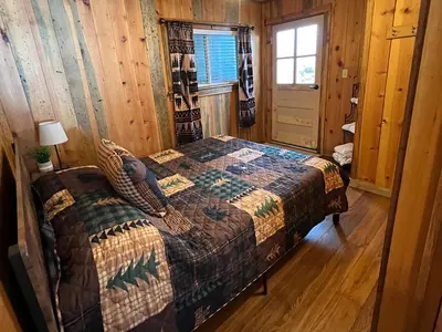 a bedroom with a bed in a log cabin at Lakeshore Resort in Lakeshore