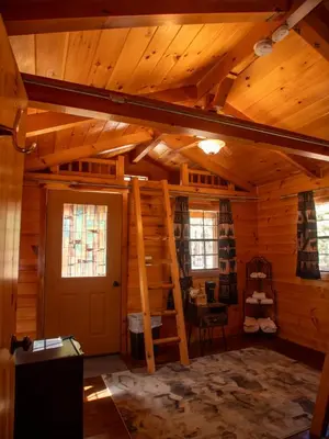 a room with a ladder in a log cabin at Lakeshore Resort in Lakeshore