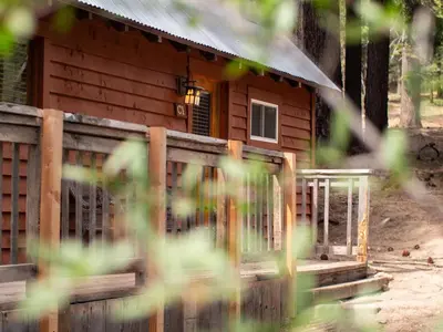 a log cabin with a fence in front of it at Lakeshore Resort in Lakeshore
