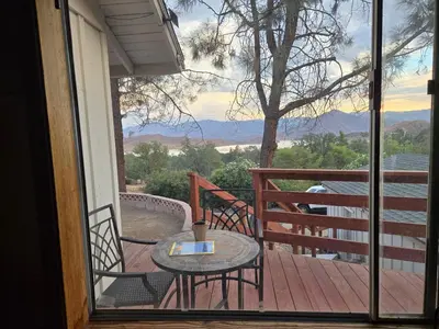 a patio with a table and chairs on a deck at Panoramic Lake View, Lake Isabella in Wofford Heights