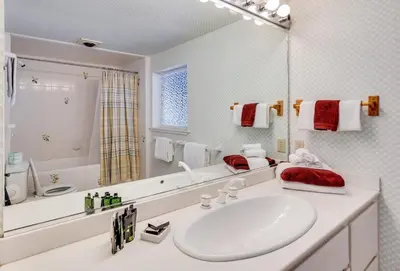 a white bathroom with a sink and a mirror at Walk to the Lake - Ski in out Amazing 5 Bdrm - VH#343 in Bear Valley