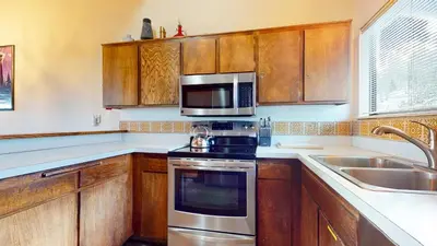 a kitchen with wooden cabinets and a stove and microwave at Mammoth Point #106 condo in Mammoth Lakes