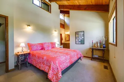 a bedroom with a red bed and two tables at Shuttle to Ski Resort Northstar Home! in Truckee