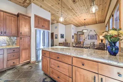 a large kitchen with wooden cabinets and a large island at Shuttle to Ski Resort Northstar Home! in Truckee