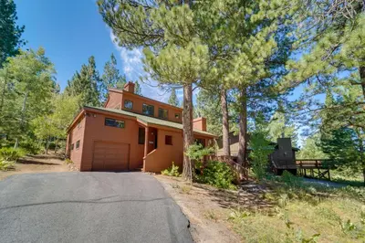 a house with a garage on the side of a road at Shuttle to Ski Resort Northstar Home! in Truckee