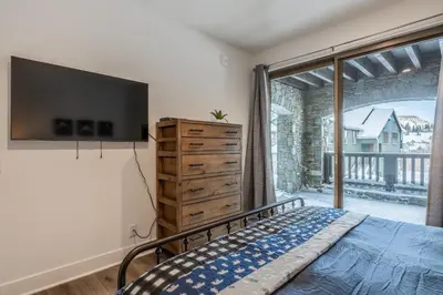 a bedroom with a bed and a large window at Newly Built Updated 3 Bed 2 and a half bath Creekhouse at Snowcrk Resort 1463 Amazing Mountain Views in Mammoth Lakes