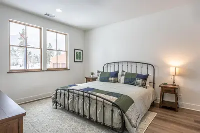 a bedroom with a bed and two windows at Newly Built Updated 3 Bed 2 and a half bath Creekhouse at Snowcrk Resort 1463 Amazing Mountain Views in Mammoth Lakes