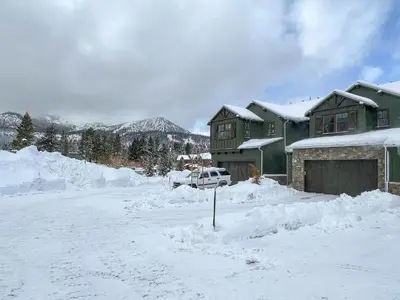 a house is covered in snow with a driveway at Newly Built Updated 3 Bed 2 and a half bath Creekhouse at Snowcrk Resort 1463 Amazing Mountain Views in Mammoth Lakes