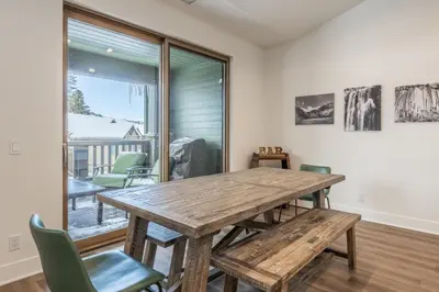 a dining room with a wooden table and chairs at Newly Built Updated 3 Bed 2 and a half bath Creekhouse at Snowcrk Resort 1463 Amazing Mountain Views in Mammoth Lakes