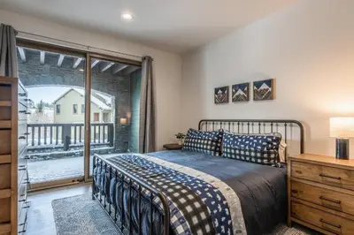 a bedroom with a bed and a balcony at Newly Built Updated 3 Bed 2 and a half bath Creekhouse at Snowcrk Resort 1463 Amazing Mountain Views in Mammoth Lakes
