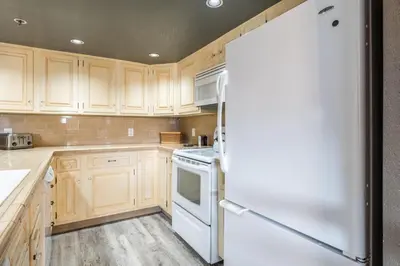 a kitchen with wooden cabinets and a white refrigerator at Bridges 112 in Mammoth Lakes